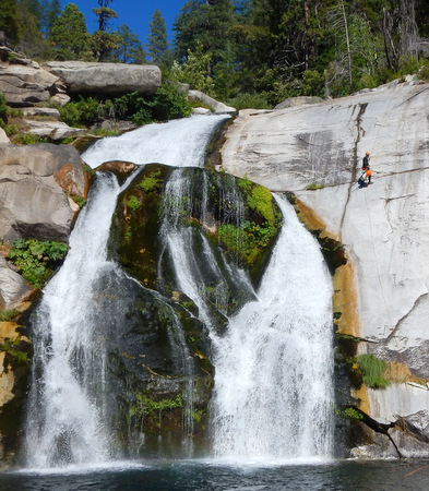Luca rappeling next to another moss-covered waterfall